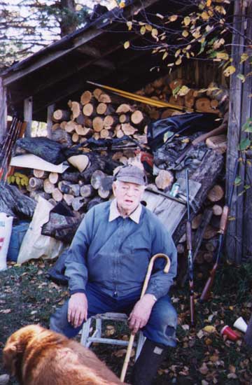 Grandad in front of the firewood supply